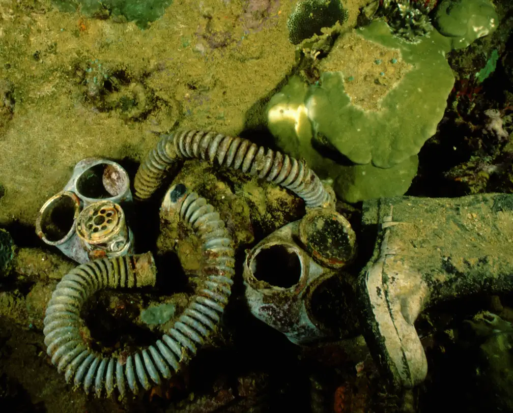 underwater photo of 2 gas masks and rubber boots from a WW2 wreck in Palau