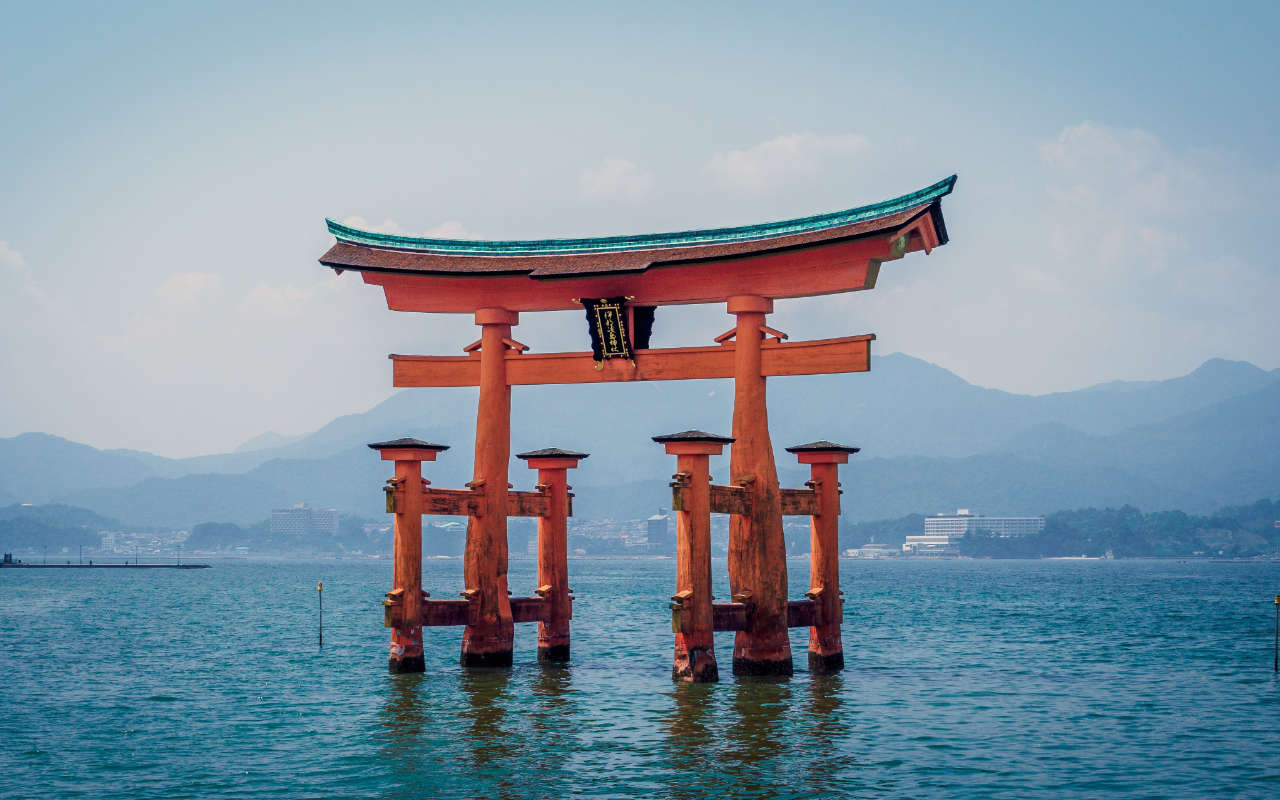 Red Japanese building resembling a japanese letter standing in the water